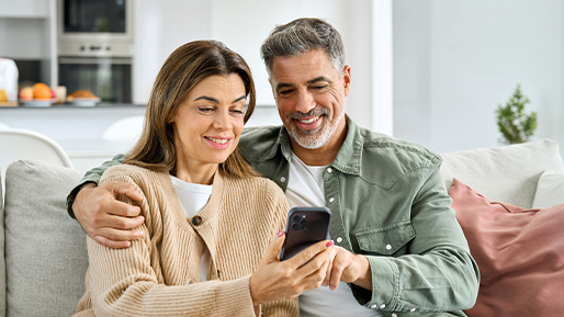 Un couple d’un certain âge signe un formulaire avec le sourire